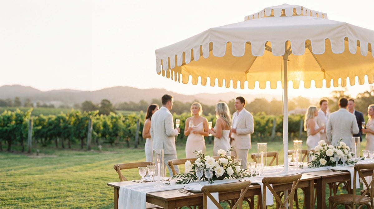 Guests at an outdoor wedding under Ivory Mist umbrellas