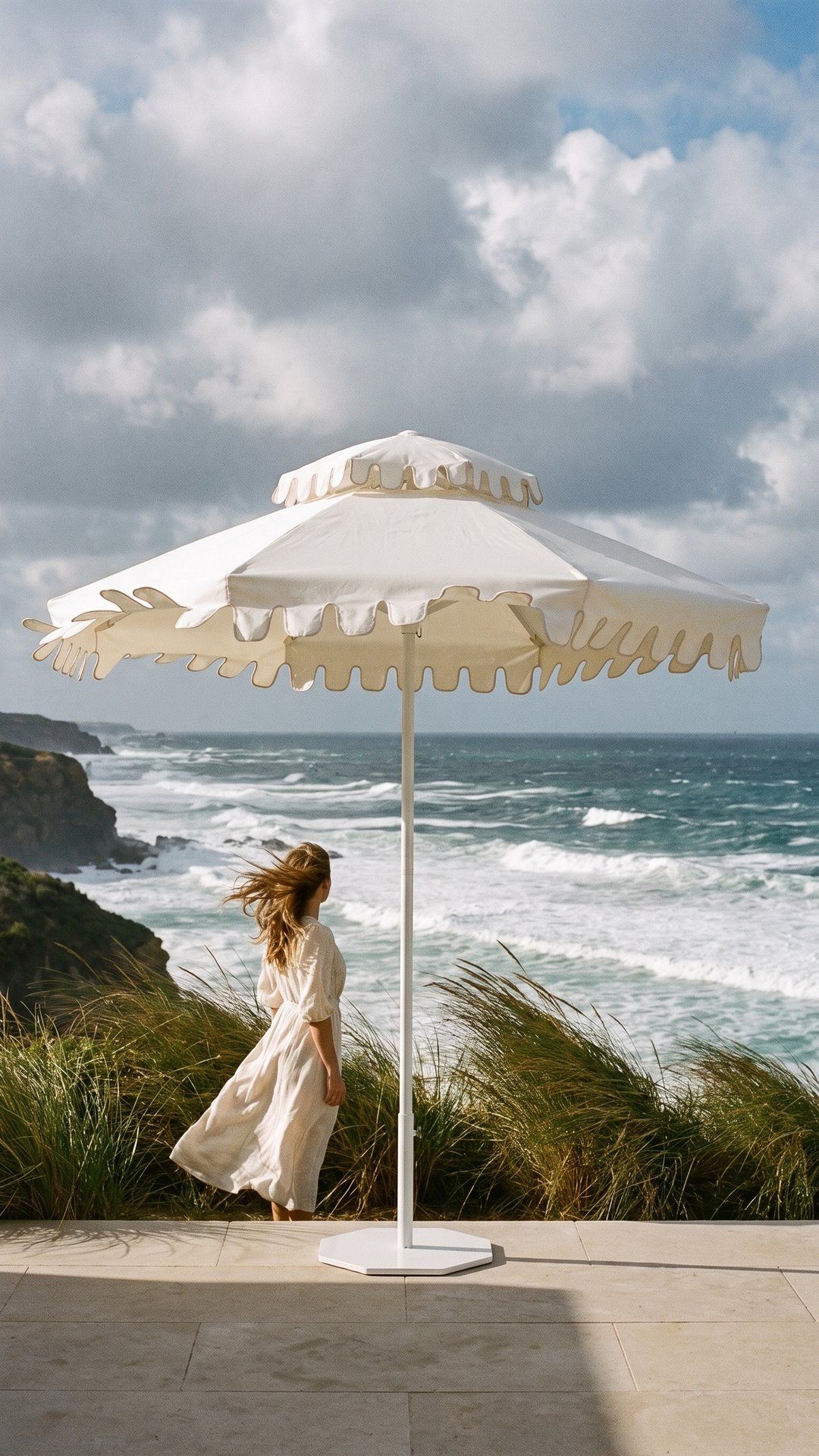 An Ivory Mist umbrella standing firm on a windy clifftop terrace