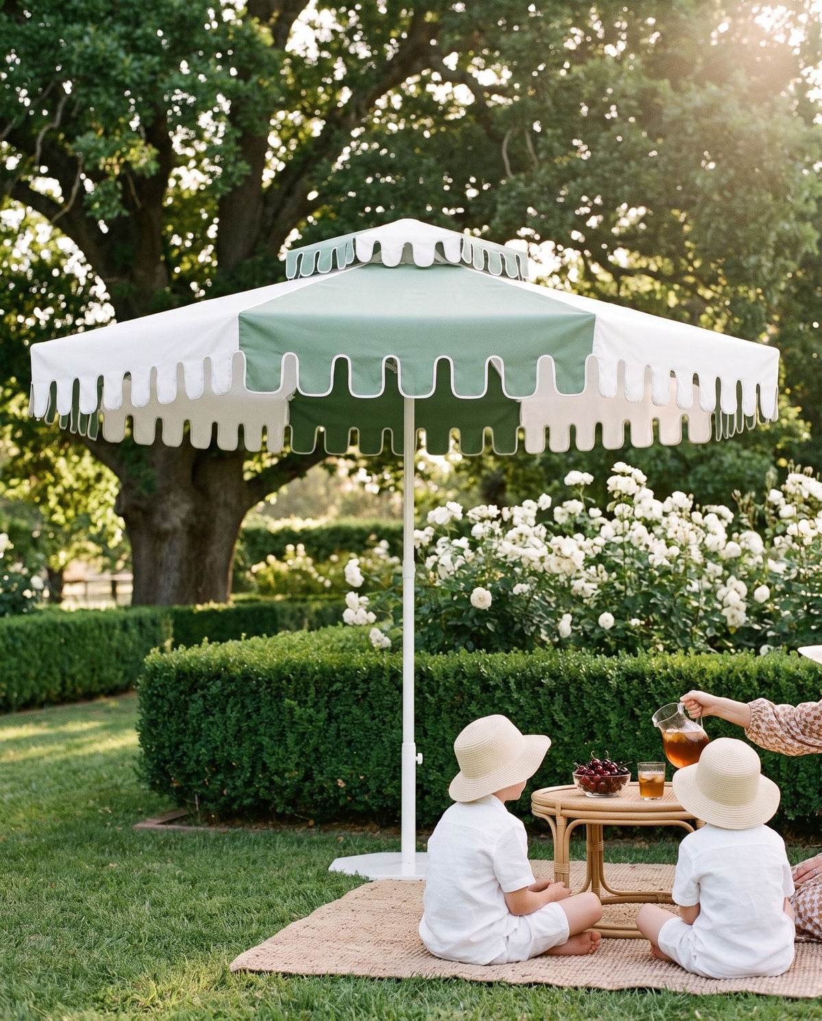 Two children in sun hats at a garden picnic under a Cactus Green umbrella