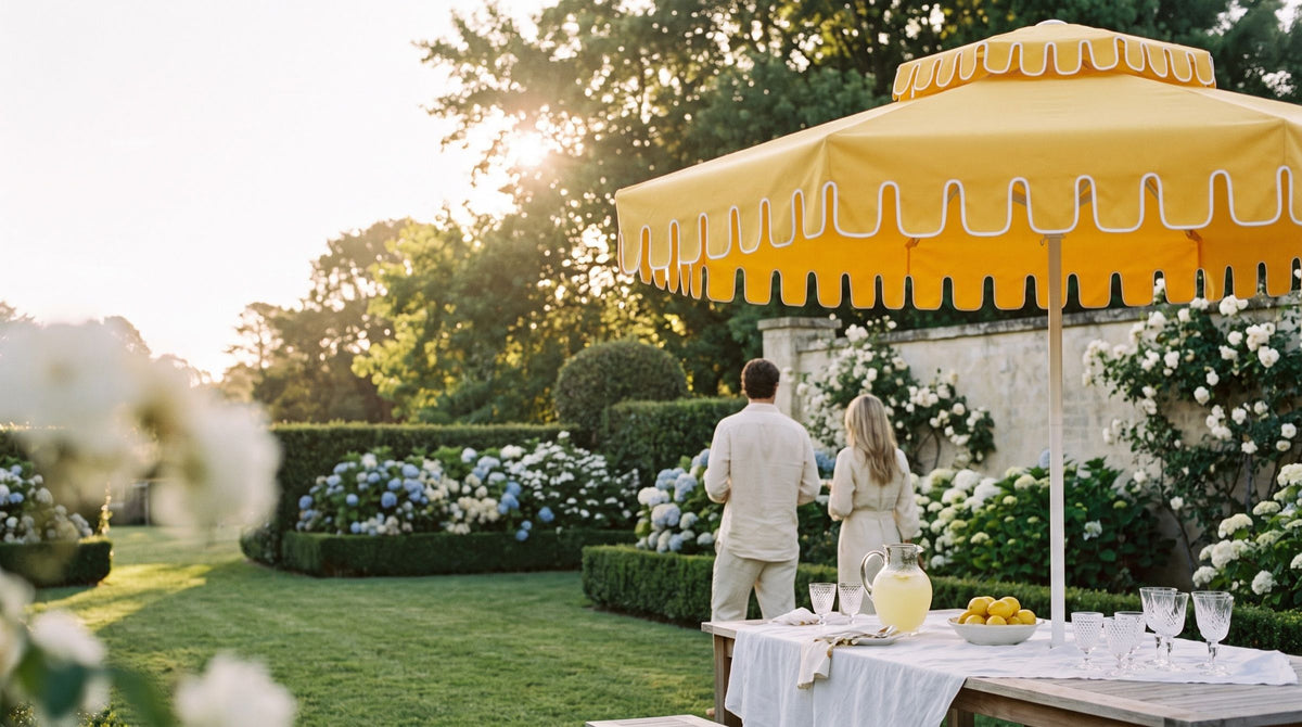 Guests in a hydrangea garden beside a long table under a Golden Hour umbrella