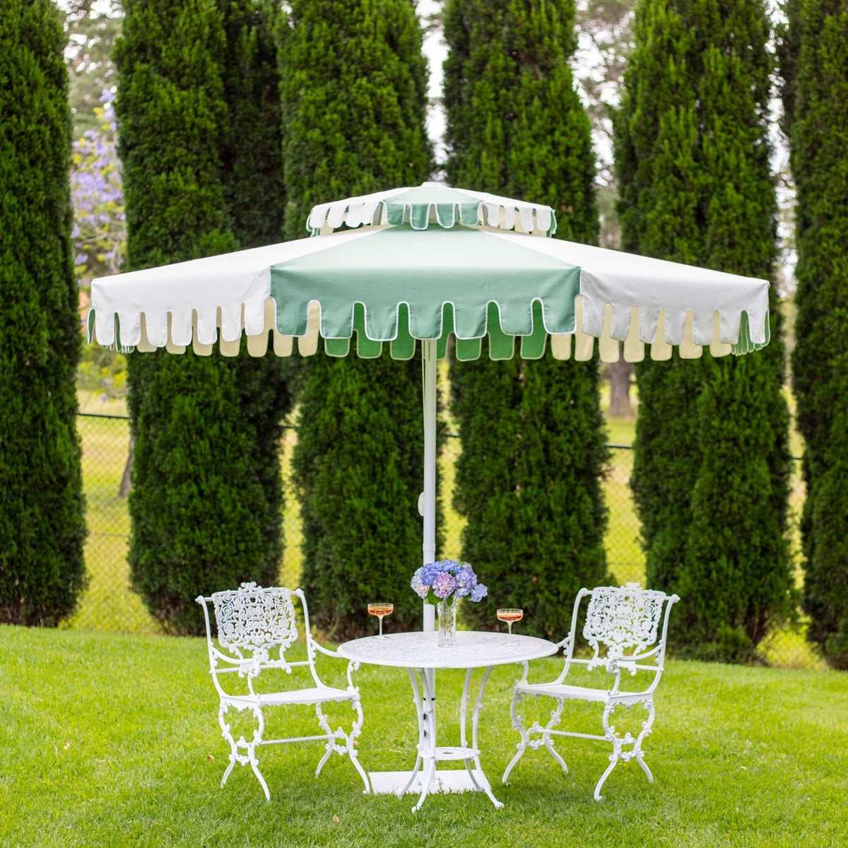 A Cactus Green umbrella shading a garden table and chairs, from our shoot